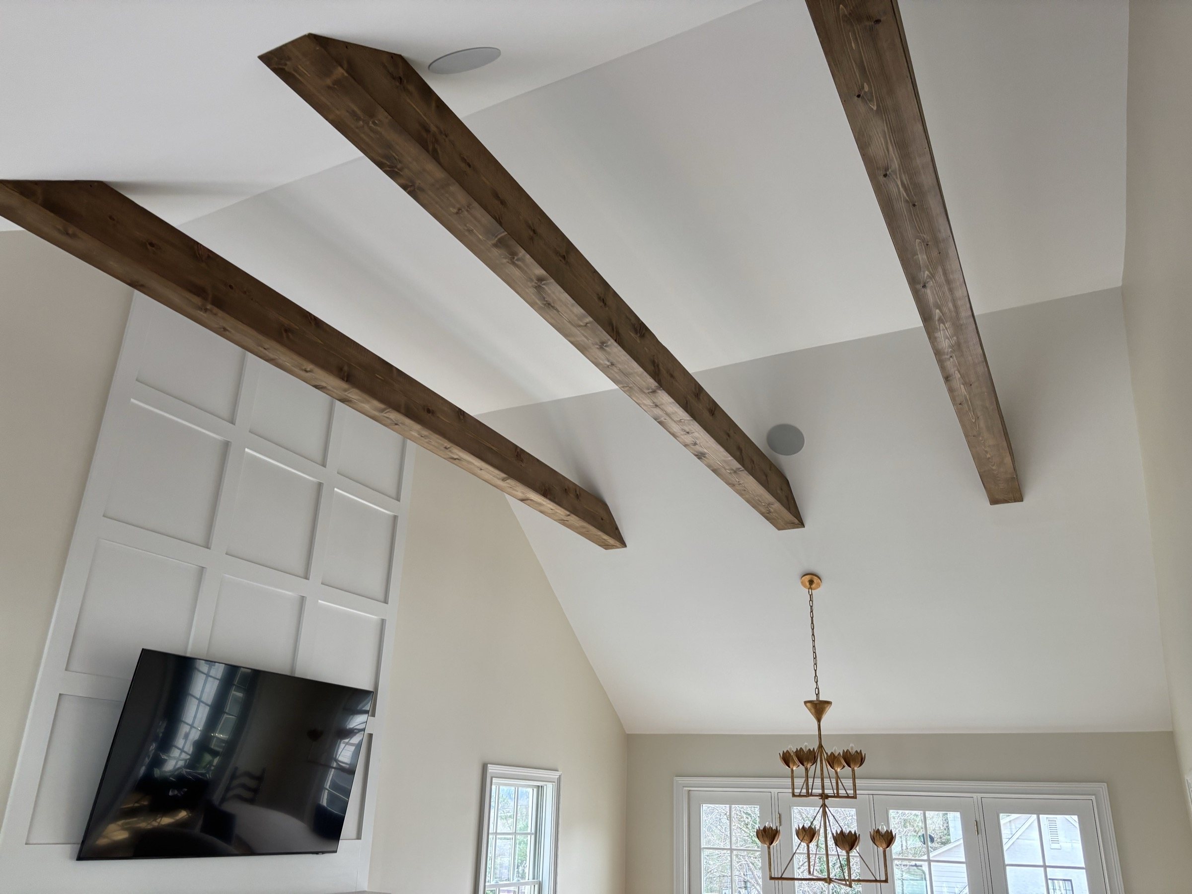 Great room with vaulted ceiling and exposed wood beams overhead