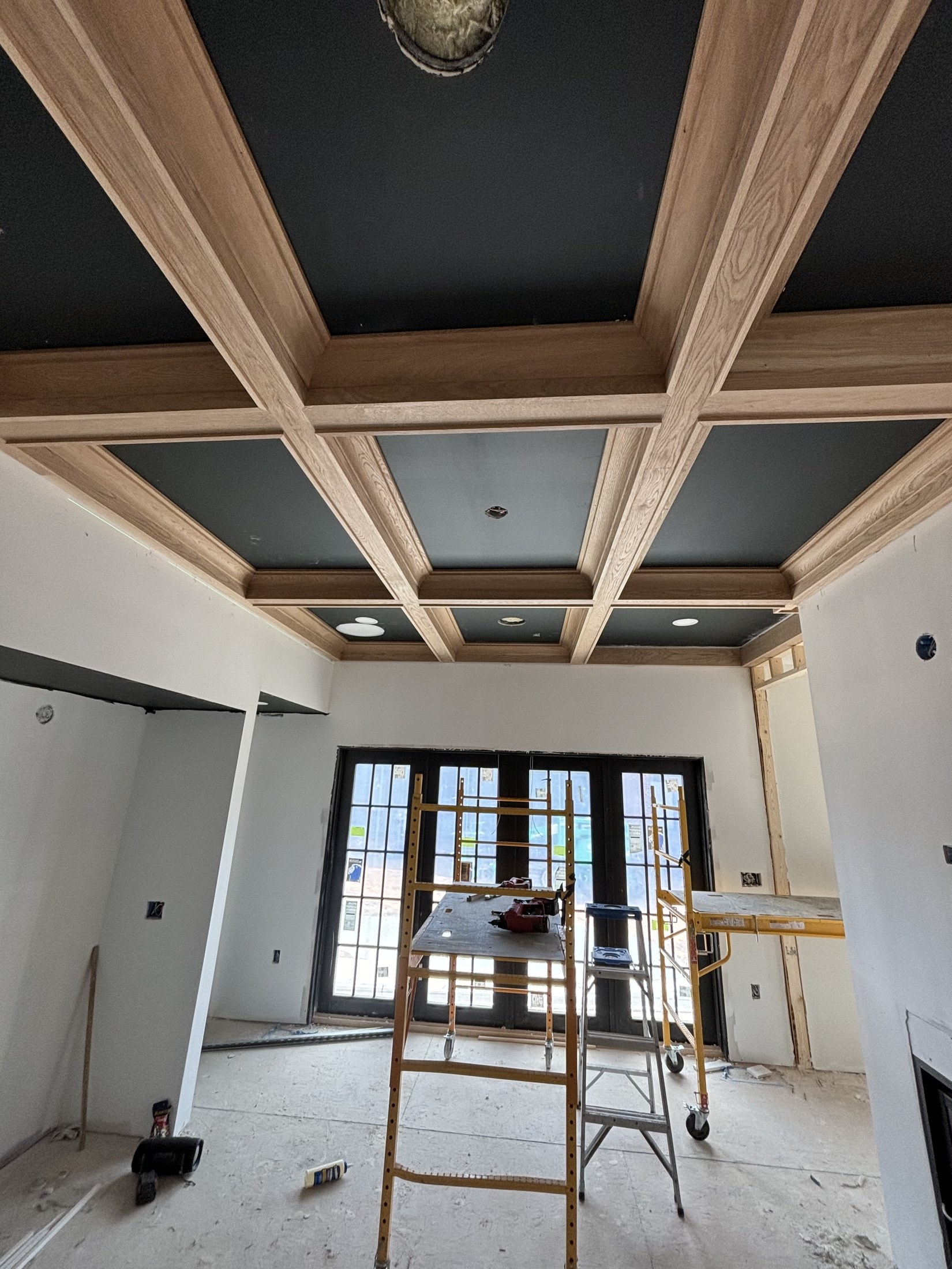 Black-painted built-in bookcases in progress, flanking a fireplace