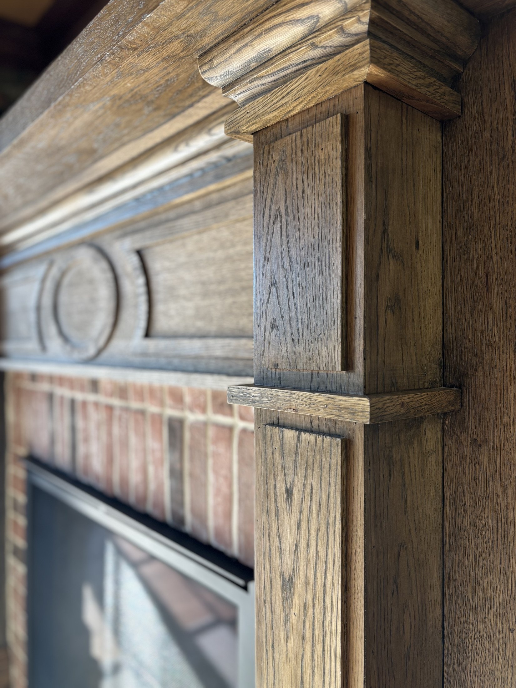 Oak fireplace mantel with carved rosette and scroll bracket detail