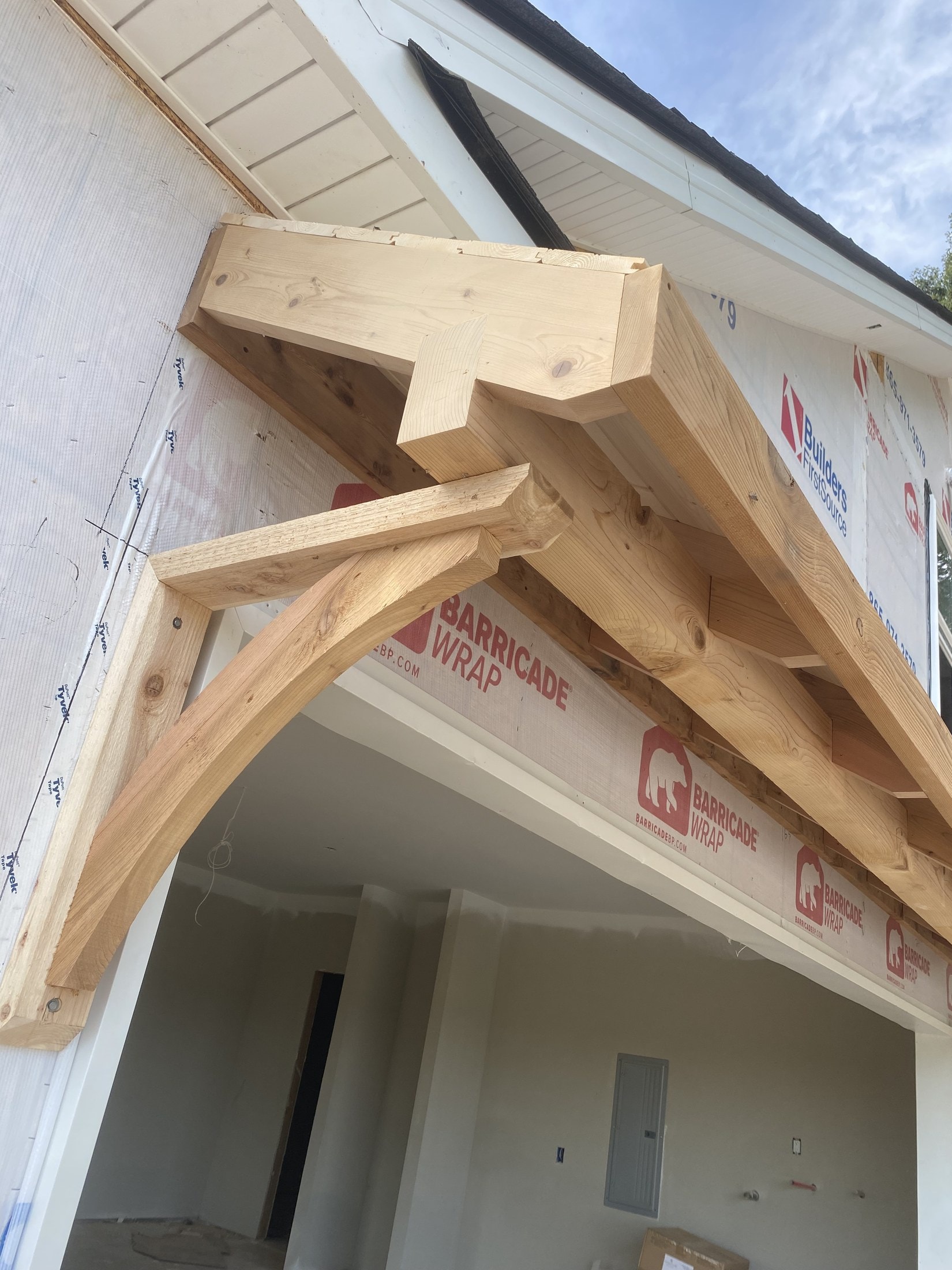 Cedar timber bracket and rafter framing on a covered porch — rough carpentry meeting finish carpentry